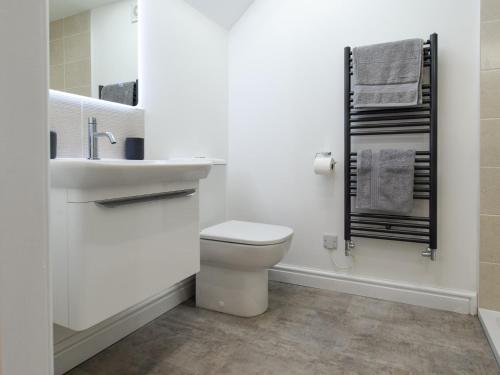 een witte badkamer met een toilet en een wastafel bij 4 Bed in Howden 93496 in Brough