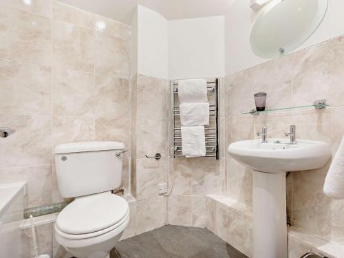 a white bathroom with a toilet and a sink at 1 Bed in Perranporth THERO in Perranporth