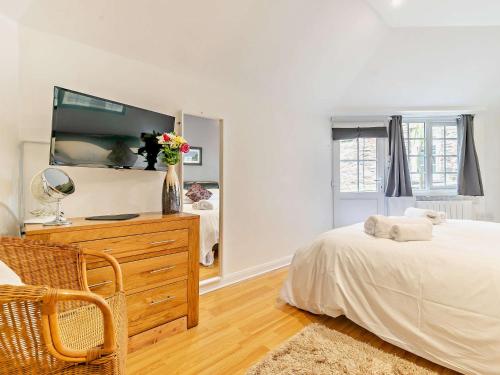 a bedroom with a bed and a dresser with a mirror at 1 Bed in Perranporth THERO in Perranporth