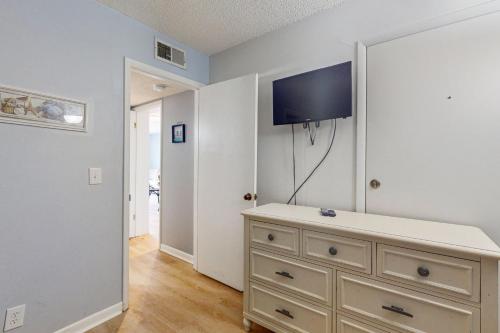 a bedroom with a dresser with a tv on the wall at Plantation East #3219 in Gulf Highlands