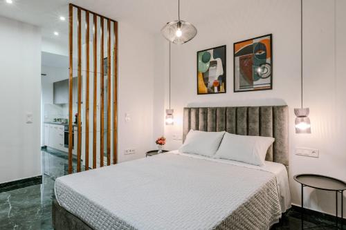 een slaapkamer met een wit bed en een keuken bij Place to be Athens apartment in Athene