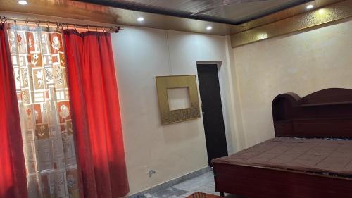 um quarto com uma cama e uma cortina vermelha em Occasions em Jammu