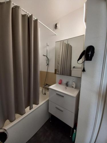 une salle de bain avec un lavabo et un rideau de douche dans l'établissement Balcon sur mer, à Saint-Gilles-Croix-de-Vie