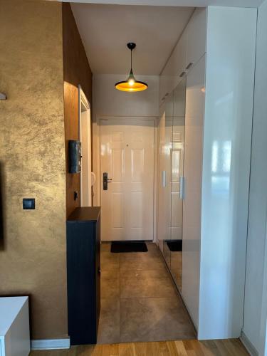 een hal met een witte deur en een glazen wand bij Apartman DM in Zvezdara