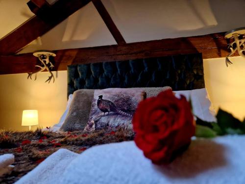 a bedroom with a bed with a red rose on it at The Hamilton - The Studio luxury holiday let's in Scorton