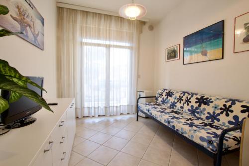 een woonkamer met een bank en een raam bij Park Residence 1 - Home Immobiliare in Lido di Jesolo