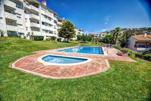 a swimming pool in front of a large apartment building at The Beach Studio by Hello Homes Sitges in Sitges