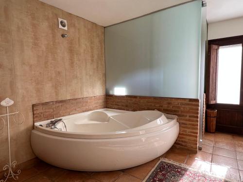 een groot wit bad in de badkamer bij Casa Mas Molines in Montrás
