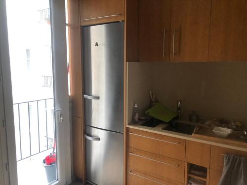 - un réfrigérateur en acier inoxydable dans une cuisine avec fenêtre dans l'établissement Appartement avec balcon dans résidence calme avec gardien -, à Paris