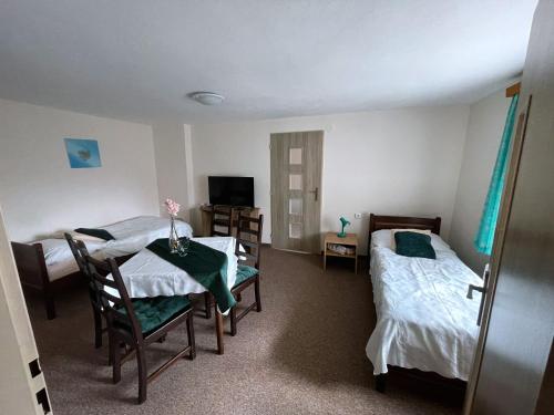 a room with two beds and a table and chairs at Hotel U Beránků in Libochovice