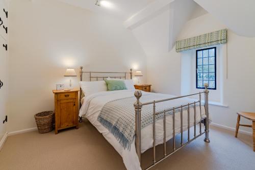 Schlafzimmer mit einem Bett und einem Fenster in der Unterkunft Charlton Down Cottage in Tetbury