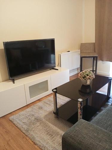 ハットフィールドにあるHighly Comfortable Homeの大型薄型テレビのあるリビングルーム