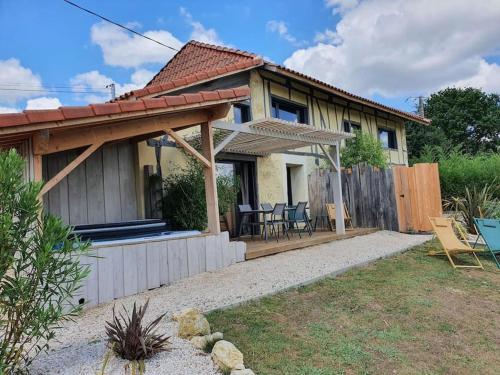 ein Haus mit einer Terrasse und einem Zaun in der Unterkunft Le Hameau - Villa de Luxe avec Piscine Intérieure & Jacuzzis in Pallanne