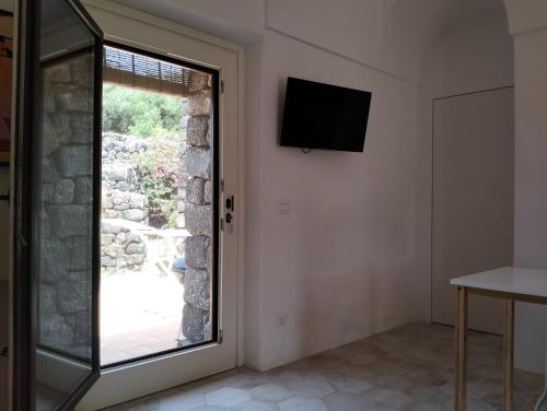 una camera con finestra e televisore sul muro di Dammusielenas a Pantelleria