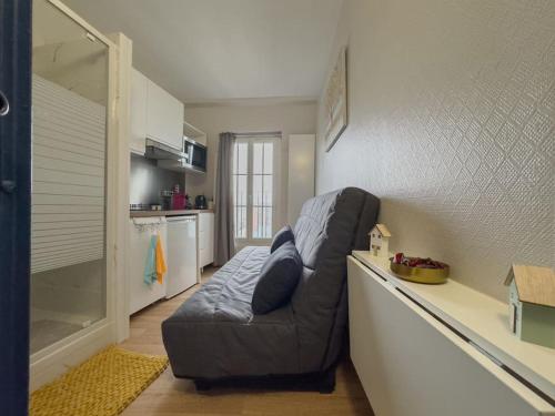 a living room with a grey couch in a kitchen at Studio Montmartre in Paris