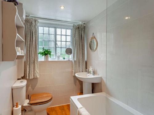 a bathroom with a tub and a toilet and a sink at 3 Bed in Shaftesbury 92395 in Melbury Abbas