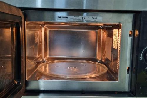 an open microwave oven with a plate in it at Apt Capitol Suite Senen 2 BR with Pool & Wifi in Jakarta