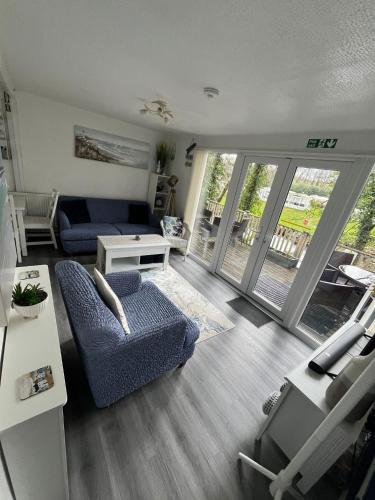 a living room with a blue couch and a table at 271 Riverside, Glan Gwna Holiday Park in Caeathro
