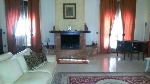 sala de estar con sofá blanco y chimenea en Villa Silvia, en Alliste