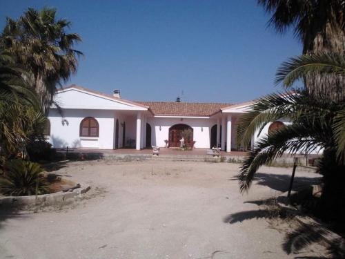 une grande maison blanche avec des palmiers devant elle dans l'établissement Villa Silvia, à Alliste