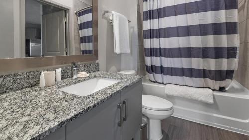 a bathroom with a sink and a toilet and a shower curtain at Landing Modern Apartment with Amazing Amenities (ID1239X542) in Middleburg