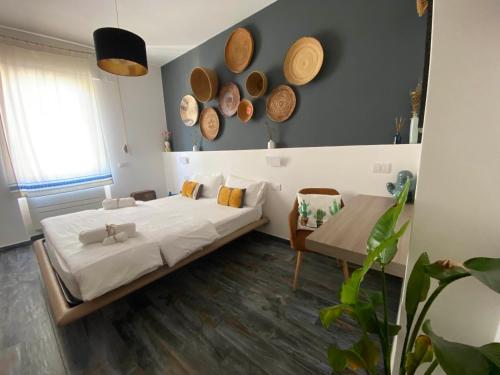 a bedroom with a bed and a table and hats on the wall at S'accabbadora Guest House in Alghero