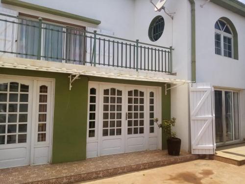 ein weißes Haus mit weißen Türen und einem Balkon in der Unterkunft Tendry Guest House in Antananarivo
