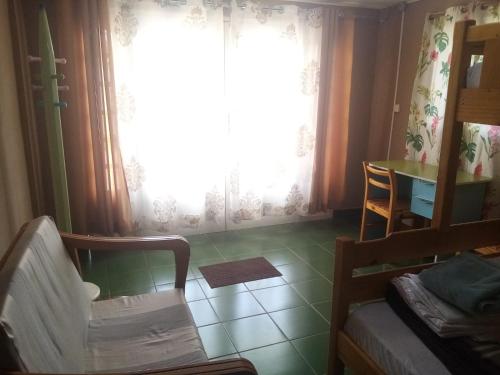 una camera con una sedia, un tavolo e una finestra di Tendry Guest House a Antananarivo
