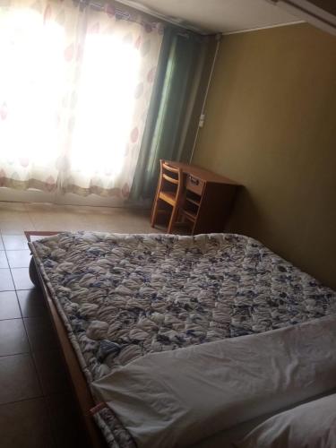 ein unmaskiertes Bett in einem Zimmer mit Fenster in der Unterkunft Tendry Guest House in Antananarivo