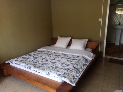 Tendry Guest House في أنتاناناريفو: سرير في غرفة نوم مع مفرش ومخدات