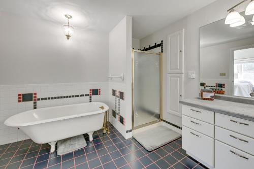 a white bathroom with a tub and a shower at Large Home with Indoor Basketball Court and Game Room! in Wisconsin Dells