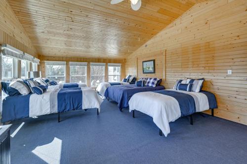 uma fila de camas num quarto com paredes de madeira em Large Home with Indoor Basketball Court and Game Room! em Wisconsin Dells