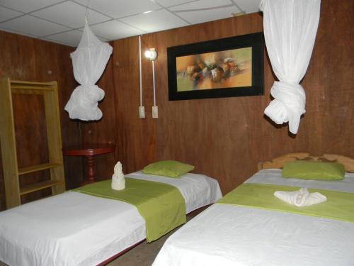 Habitación con 2 camas y una foto en la pared. en Bromelia Flower Lodge Iquitos, en Iquitos