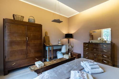 een slaapkamer met een bed, een dressoir en een spiegel bij Casa Montalgallo in Lucignano