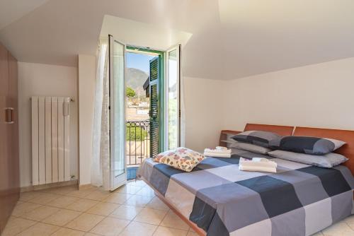 ein Schlafzimmer mit einem großen Bett und einem Balkon in der Unterkunft [5 min dal MARE] Luminoso Bilocale con Terrazza in Loano