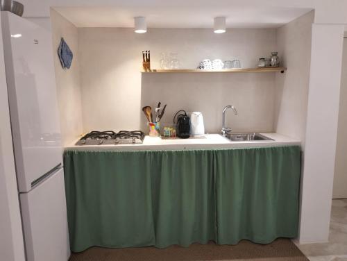 une cuisine avec une table et un chiffon vert dans l'établissement Dammusielenas, à Pantelleria