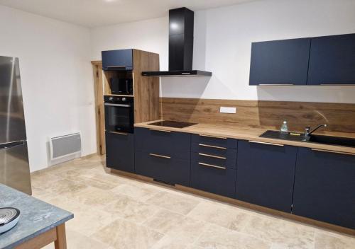 une grande cuisine avec des placards bleus et un évier dans l'établissement Appartement de charme - CARPENTRAS - Rendez-vous en Provence, à Carpentras