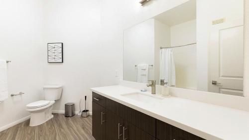 Baño blanco con aseo y lavamanos en Landing Modern Apartment with Amazing Amenities (ID9071X06), en San Diego