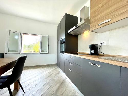 cocina con mesa de madera y encimera en Green House, en Cardedu