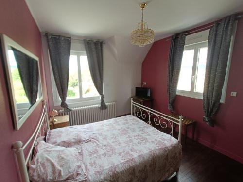 um quarto com uma cama com paredes vermelhas e janelas em maison de village em Chérencé-le-Roussel