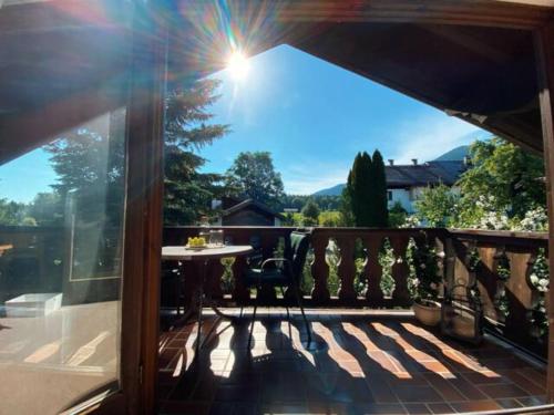 a balcony with a table and a view of the mountains at Moderne Alpenwohnung Garten & Naturpool in Bad Kohlgrub
