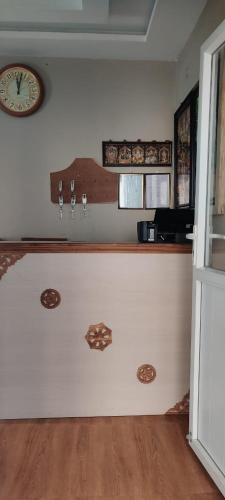 eine Küche mit einer Theke mit einer Uhr an der Wand in der Unterkunft Silver Oak stay in Yercaud