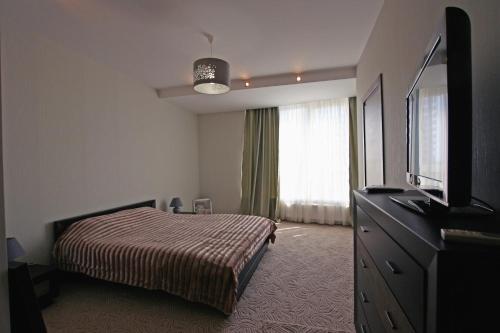 a bedroom with a bed and a flat screen tv at Mini hotel in Observatorniy in Odesa