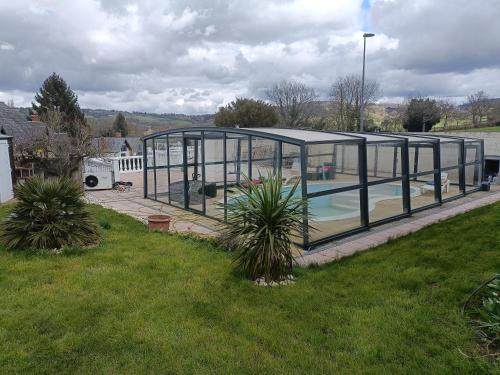 une piscine dans une serre dans une cour dans l'établissement Maison Rose, à Chérencé-le-Roussel