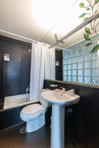 a bathroom with a toilet and a sink and a tub at El Balcón de Samil in Vigo