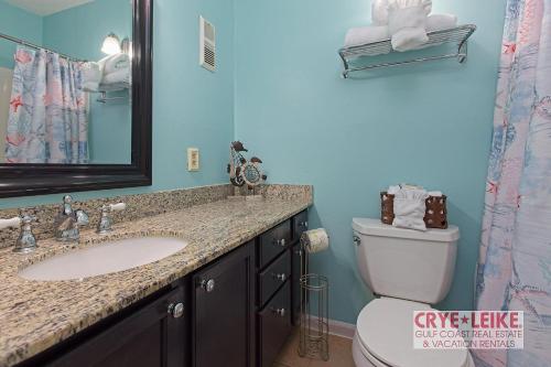 uma casa de banho com um lavatório, um WC e um espelho. em Sea Breeze 305 em Gulf Shores