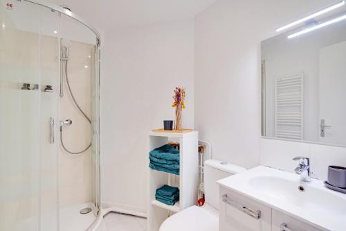 a bathroom with a shower and a toilet and a sink at Parisian Charm Porte Maillot in Paris