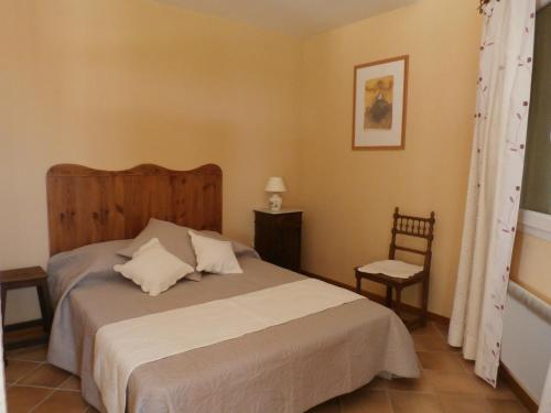 une chambre avec un grand lit et une chaise dans l'établissement Loumasfasua, à Saint-Marcel-dʼArdèche