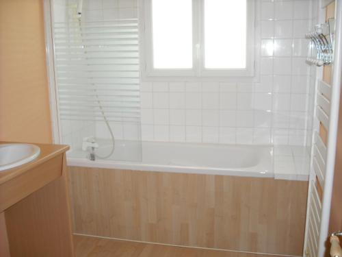 une salle de bain avec une baignoire, un lavabo et une fenêtre dans l'établissement Loumasfasua, à Saint-Marcel-dʼArdèche