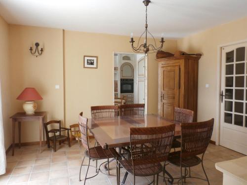 une salle à manger avec une table et des chaises en bois dans l'établissement Loumasfasua, à Saint-Marcel-dʼArdèche